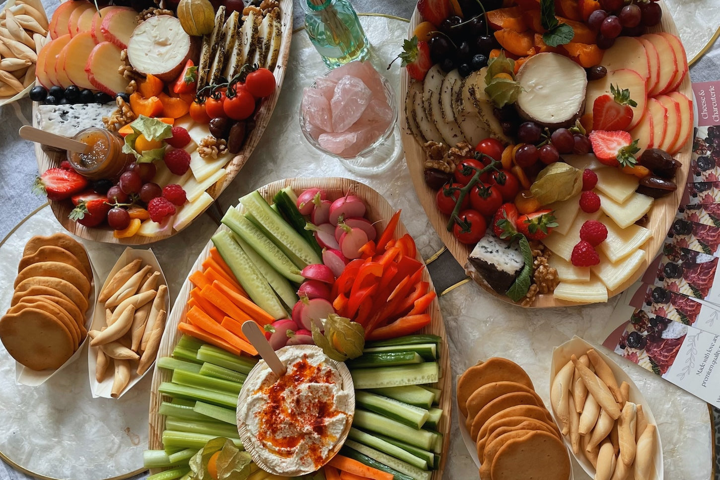 Grazing table with a range of baords displaying spanish cheese and Iberico charcuterie, as well as hummus and veggies